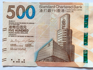 a close up on the front side of five hundred hongkong dollar banknote, with the headquarter building of standard chartered bank