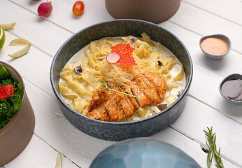 Fettuccine Alfredo with chicken sliced ​​steak. creamy sauce and pasta And grated cheese and Mushrooms create an appealing presentation for restaurant .