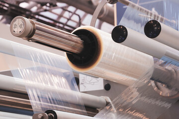 Automatic polyethylene plastic bag production machine with lighting effect. Close-up of the roller...