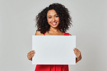 An advertisement studio template portrait photo of a person: a woman in a red dress with a bright smile on her face, holding a blank sign in her hands against a white background.