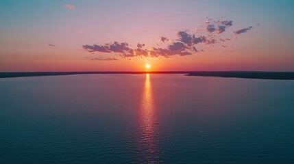 Naklejka premium Vibrant Sunset Over Calm Waters with Beautiful Cloud Patterns in the Sky