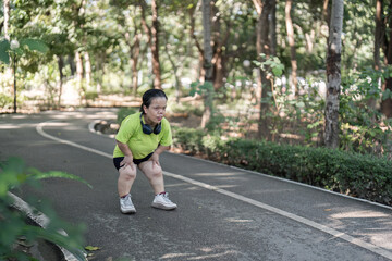 Exhausted Woman Taking a Break While Jogging in a Lush Green Park on a Sunny Day