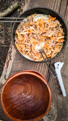 Delicious mushroom pan with noodles, mushroom dish made from fresh chanterelles with noodles in a cream sauce in the outdoor kitchen