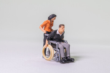 miniature figure concept of disable people	
