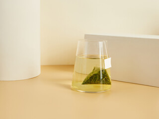 tea bags brewed in a glass, in a beautiful minimalist composition on a beige background