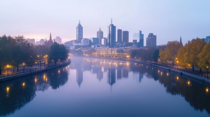 Obraz premium Melbourne city skyline at dawn. Modern skyscrapers reflect in calm river. Trees line waterfront park. Soft light bathes buildings in golden hue. City lights reflect on water. Peaceful atmosphere.