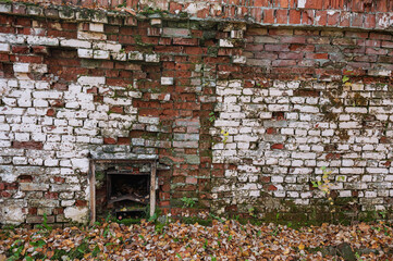 Weathered brick wall with peeling red and white texture