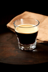 Coffee in glass cup on dark background. Close up. Copy space	