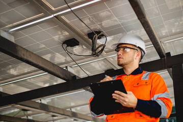 Electrical engineer is rigorously checking the circuitry and integrity of solar panel installations.