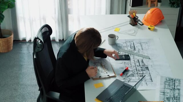 Top view of architect engineer drink coffee and draw blueprint at meeting table with equipment and safety helmet scatter around. Aerial view of project manager looking at project plan. Alimentation.