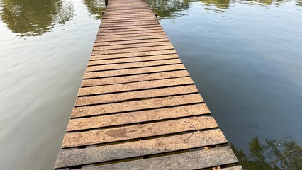 Obraz premium wooden bridge across the river Go to the forest on the opposite side. with dense trees.