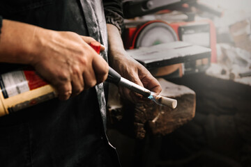 Hands using blowtorch in carpentry workshop