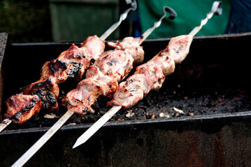 Meat kebab on skewer cooked on grill outside, lunch in meat restaurant