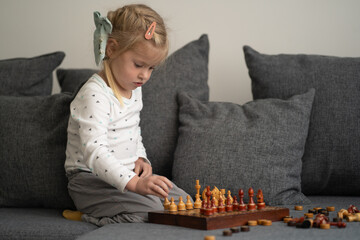 A young girl setting up a chessboard and starting to play. Perfect for educational content, games, strategy, and childhood development themes. Ideal for promoting cognitive skills, learning.