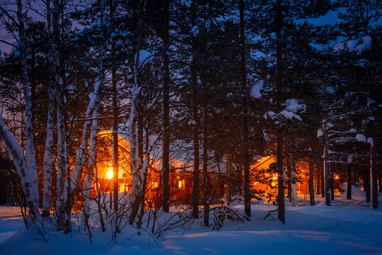 Wooden Cottages in the Night Snowy Forest