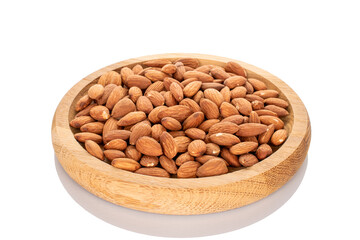 Fragrant roasted almonds on a wooden tray, close-up, isolated on a white background.