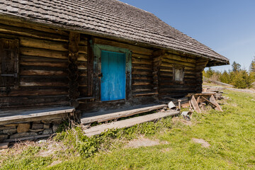 Rustic Wooden Cabin with Vibrant Blue Door Surrounded by Nature