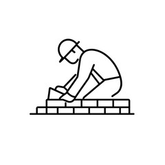 Skilled worker laying bricks during construction at a building site in a city during daylight hours