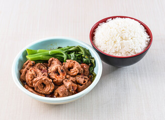 Braised pork intestine with white rice and kailan served in bowl isolated on white background side view of hong kong food