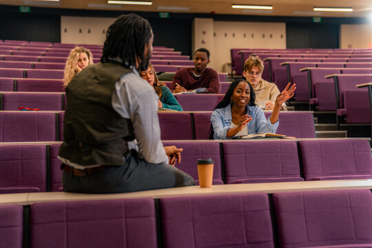University student asking question to professor in lecture hall