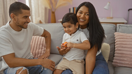 Family enjoying togetherness with a woman, man, and child smiling happily in a cozy living room at home