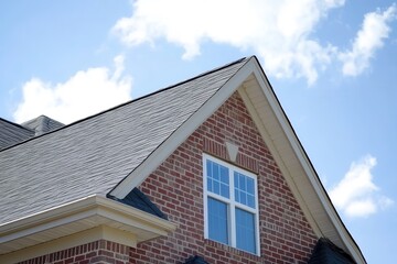 Close up of a luxury single family home featuring a dual gable design Traditional roof with a square window