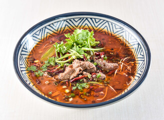 Sichuan Boiled beef topped with red pepper, coriander and green onion served in bowl isolated on white background side view of hong kong food
