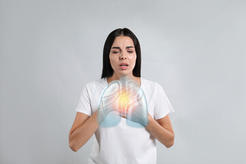 Woman with asthma suffering from difficulty breathing on grey background. Illustration of lungs