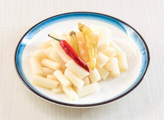 Spicy and Sour Lotus Root Tips with red chillies served in bowl isolated on white background side view of hong kong food