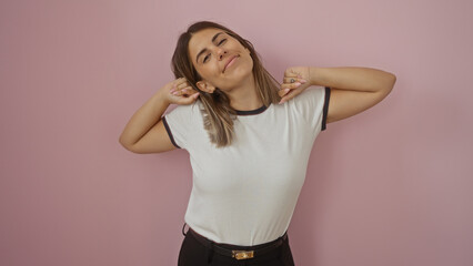 Young woman with brunette hair isolated over a pink background in a playful pose demonstrating her attractive and cheerful personality