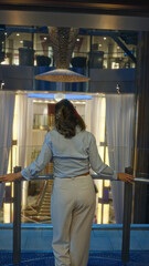 Woman enjoying the luxurious hall of a cruise ship with elegant decor and soft lighting indoors, capturing a moment of serene beauty.
