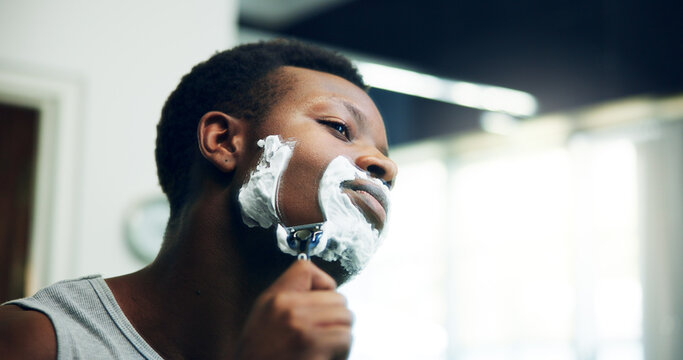 Black man, shave and razor with face cream for grooming, epilation or hair removal in bathroom at home. African, male person or facial with blade, aftershave creme or clean beard for skincare routine