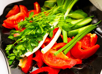 Freshly chopped vegetables on a black platter ready for preparation