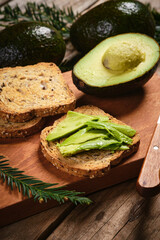 Delicious avocado toast with fresh avocados on wooden board