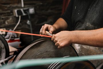 Hands sharpening tool in artisan workshop