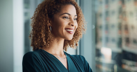 Fototapeta premium Woman, happy or thinking at window for business, future or planning for career development in office. Corporate, professional or reflection in firm for decision with opportunity for industry growth