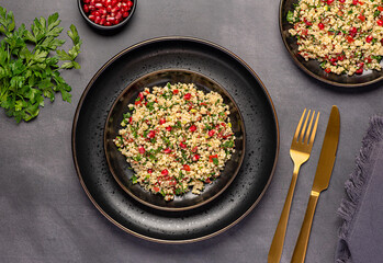 Food photography of salad tabouleh with pomegranate, bulgur; parsley, mint, tomato, spring onion, vegan dish, Arabian food