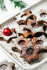 Traditional Linz Christmas cookies filled with quince jam on a white wooden background