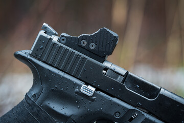 Modern red dot sight mounted on a pistol, close-up photo. Tactical weapon.