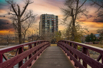 A rusty colored bridge over the Truckee River with autumn trees and plants at sunset in Reno Nevada USA