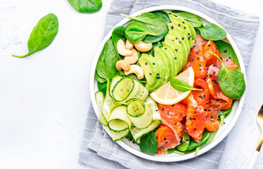 Salad with ssalted almon, avocado, spinach, cucumber, sesame and cashew. White background, top view