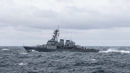 Sleek navy destroyer navigating choppy waters under dramatic sky