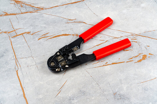 Modular plug crimper for RJ45 on marble background.