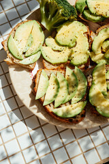 Avocado toast on plate on kitchen table, breakfast on sunny morning. healthy eating, vegetarian. top view of food. nutritious lunch, delicious and balanced.