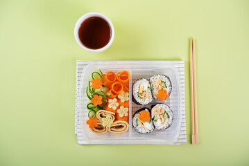 Bento box with sushi set with chicken filling and vegetables