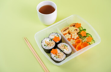 Bento box with sushi set with chicken filling and vegetables