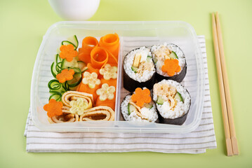 Bento box with sushi set with chicken filling and vegetables
