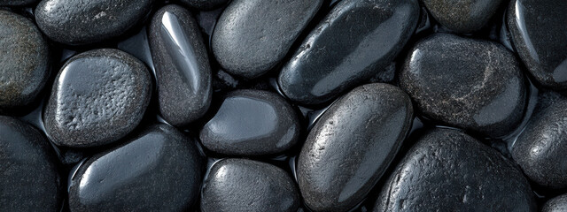 Smooth pebbles on a wet beach, natural texture with shiny surfaces