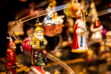 Christmas decorations colorful balls and toys, fir tree branches and cones, lanterns, small angel and Santa figures. Christmas market fair in Europe. Preparation for celebration of xmas and New Year