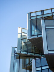 Design and construction of a modern building. Glass and concrete. Building of unusual geometric shape.